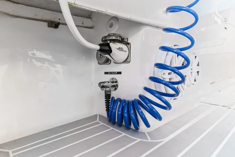 Slide: The Image of 2016 Intrepid 400 Cuddy boat with blue coiled hose and saltwater outlet. - 44