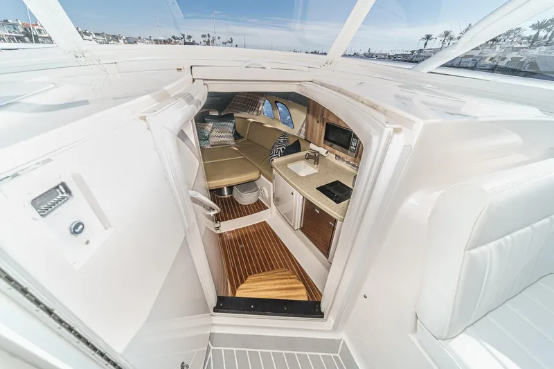 Slide: The Image of Interior view of 2016 Intrepid 400 Cuddy, featuring a cozy cabin and kitchenette. - 49