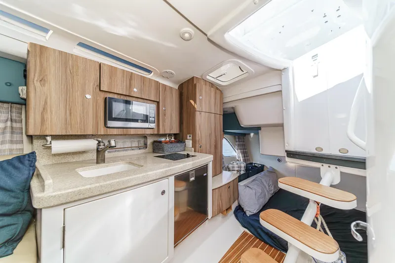 Slide: The Image of 2016 Intrepid 400 Cuddy interior with kitchenette, microwave, and cozy sleeping area. - 53