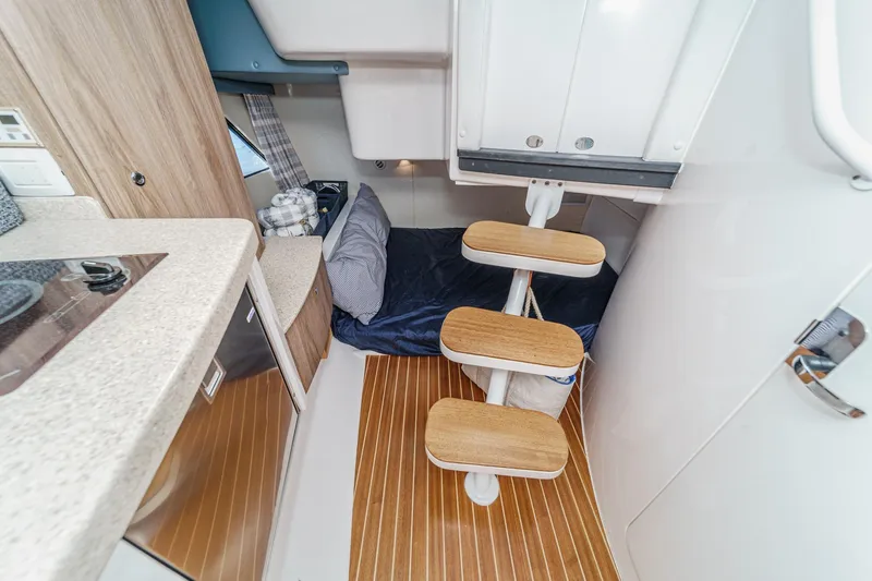 Slide: The Image of Interior of 2016 Intrepid 400 Cuddy, featuring compact kitchen and cozy sleeping area. - 55