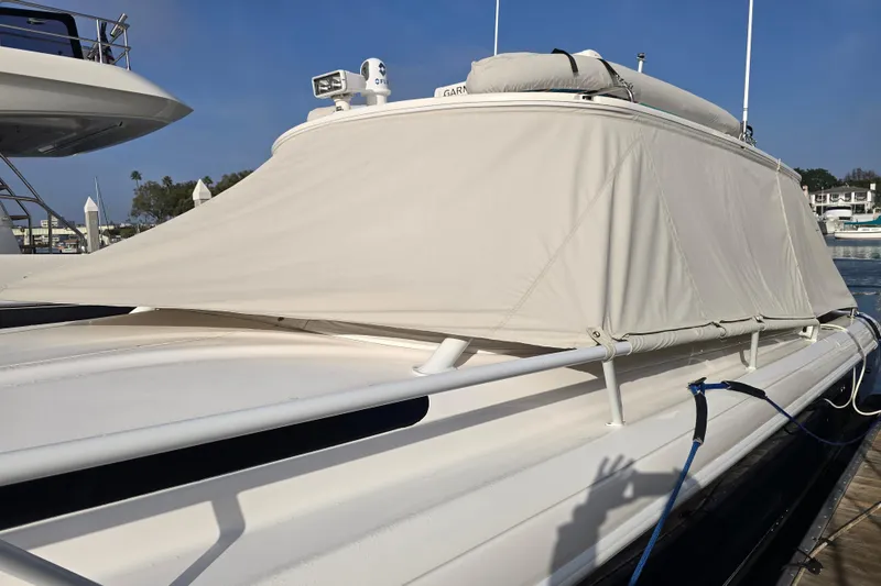 Slide: The Image of 2016 Intrepid 400 Cuddy boat with protective cover docked at marina. - 60