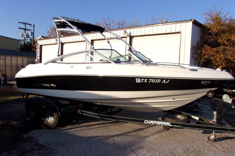 The Image of 2007 Chaparral 210 SSi boat on trailer, parked outdoors near storage buildings. - 1