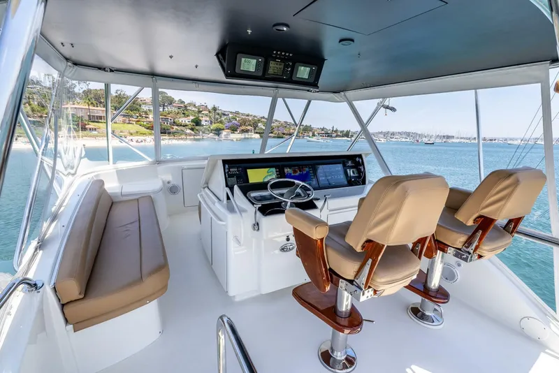 Slide: The Image of 2004 Hatteras 54 Convertible yacht helm with dual captain chairs and panoramic ocean view. - 33