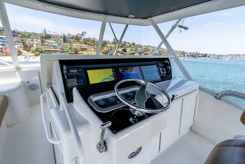 Slide: The Image of Helm of 2004 Hatteras 54 Convertible yacht with navigation equipment and ocean view. - 35