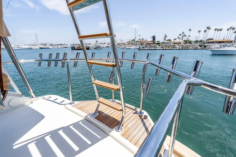 Slide: The Image of 2004 Hatteras 54 Convertible yacht deck with ladder, overlooking marina and calm waters. - 38