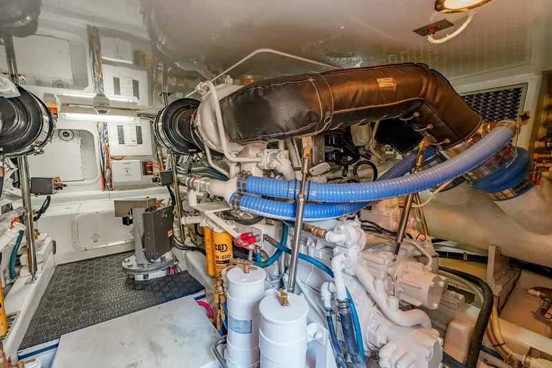 Slide: The Image of Engine room of 2004 Hatteras 54 Convertible yacht, showcasing complex machinery and piping. - 43