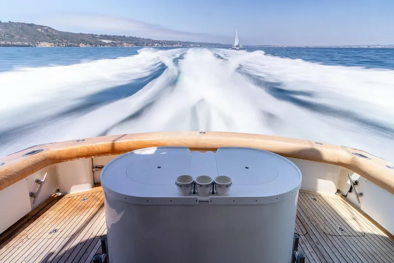 Slide: The Image of 2004 Hatteras 54 Convertible yacht cruising with wake view, wooden deck, and ocean scenery. - 6