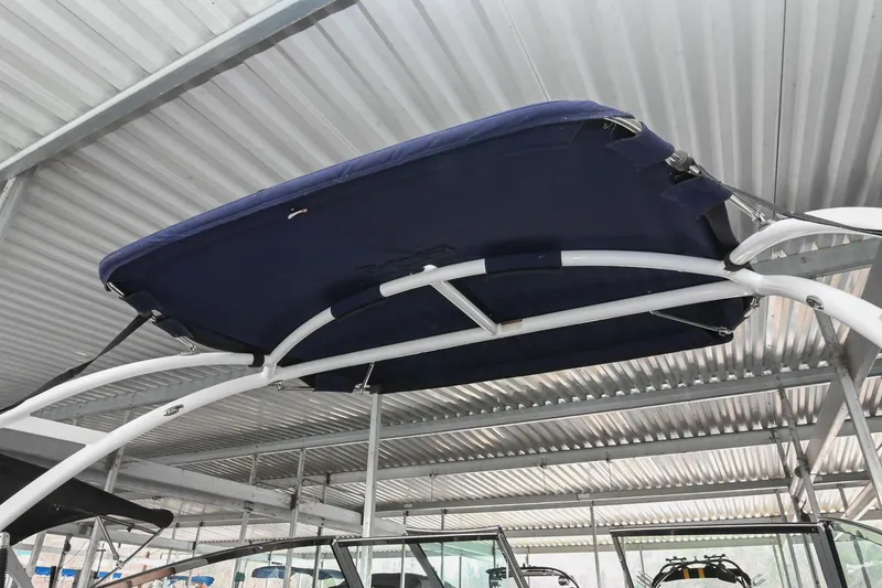 Slide: The Image of 2015 Cobalt R7 boat with blue bimini top under metal roof. - 19
