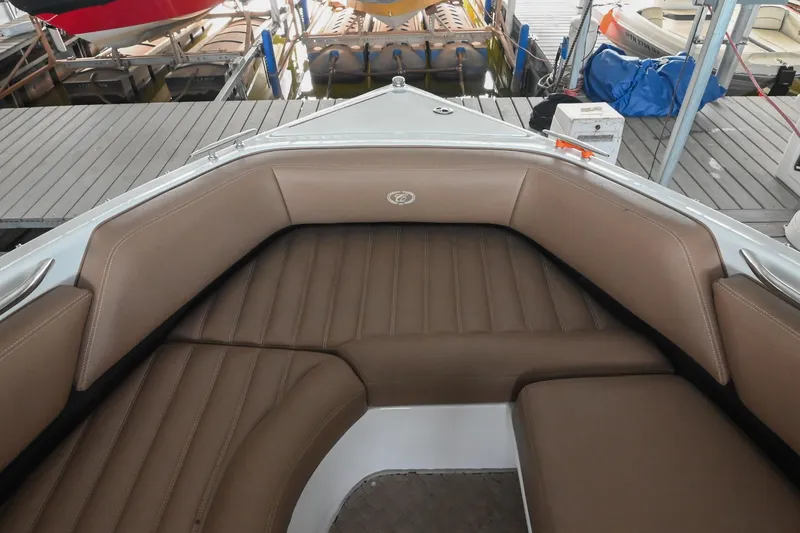 Slide: The Image of 2015 Cobalt R7 boat interior with brown leather seating at a marina. - 40