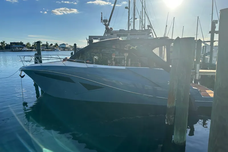 Slide: The Image of 2025 NX Boats 370 docked at marina under clear sky. - 1