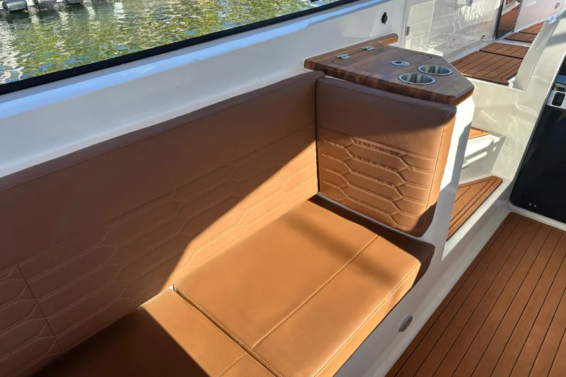 Slide: The Image of Luxurious seating on 2025 NX Boats 370 with elegant brown upholstery and cup holders. - 103