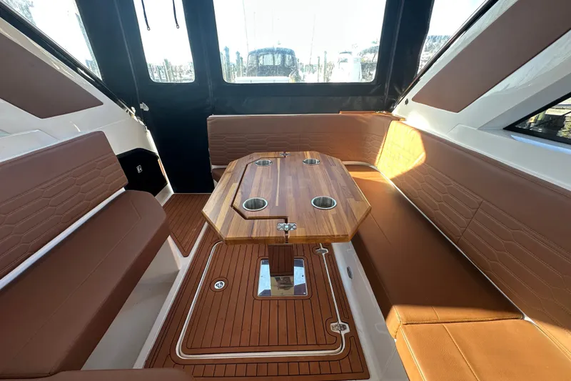 Slide: The Image of Interior of 2025 NX Boats 370 with brown seating and wooden table. - 106