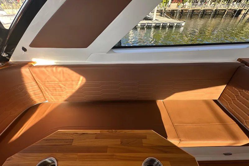 Slide: The Image of Luxurious interior of 2025 NX Boats 370 with brown leather seating and wood accents. - 107