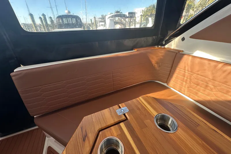 Slide: The Image of Interior of 2025 NX Boats 370 with brown leather seating and wooden table. - 108