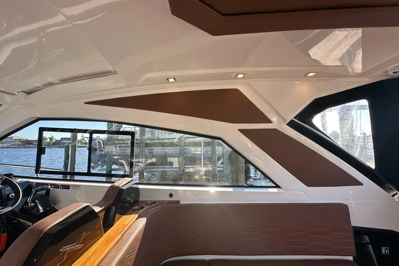 Slide: The Image of Interior of 2025 NX Boats 370, featuring sleek design and luxurious seating by the water. - 111