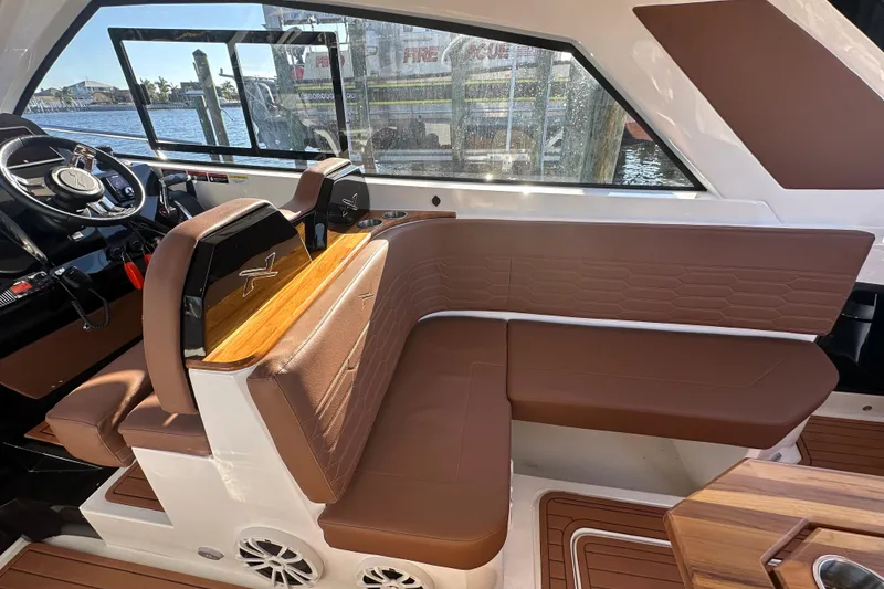 Slide: The Image of 2025 NX Boats 370 interior with brown leather seating and modern steering wheel. - 112