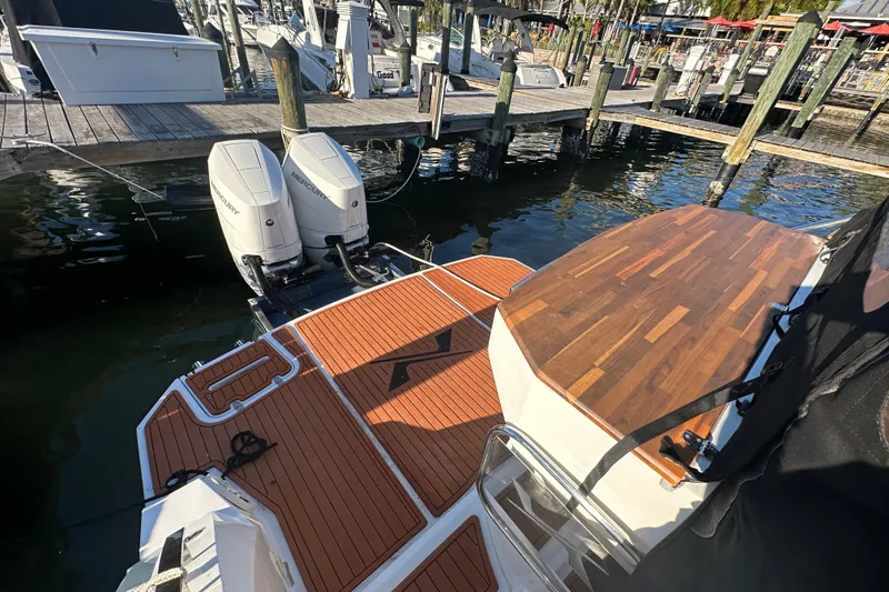 Slide: The Image of 2025 NX Boats 370 with dual Mercury engines docked at a marina. - 116