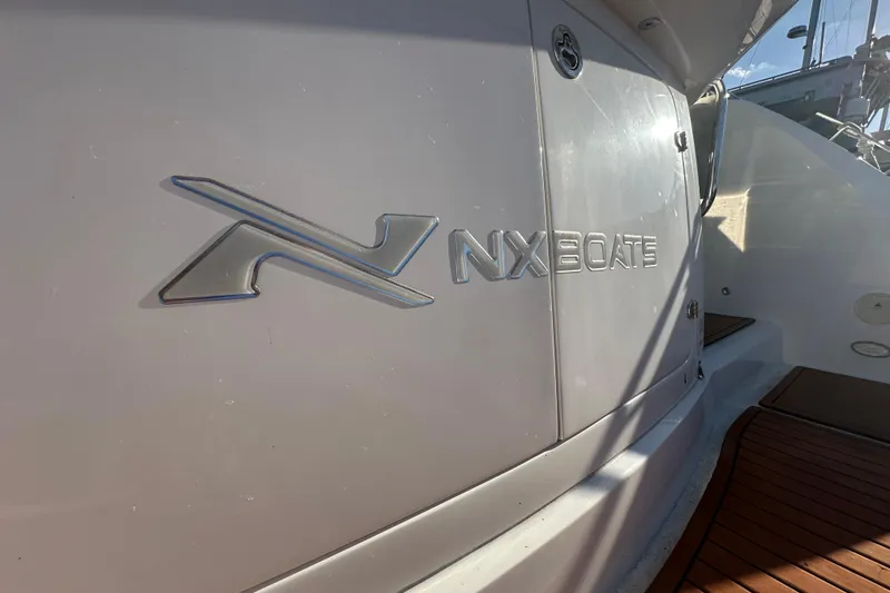 Slide: The Image of 2025 NX Boats 370 logo on sleek white boat exterior. - 13