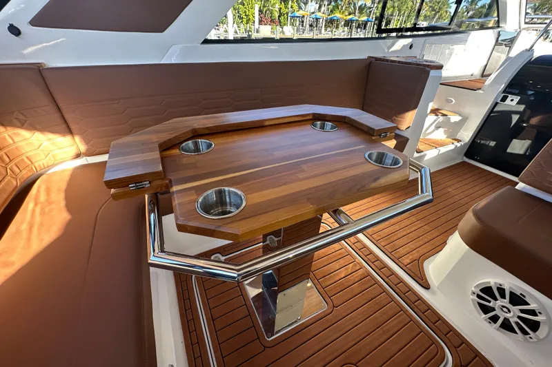 Slide: The Image of Luxury interior of 2025 NX Boats 370 with wooden table and cup holders. - 17