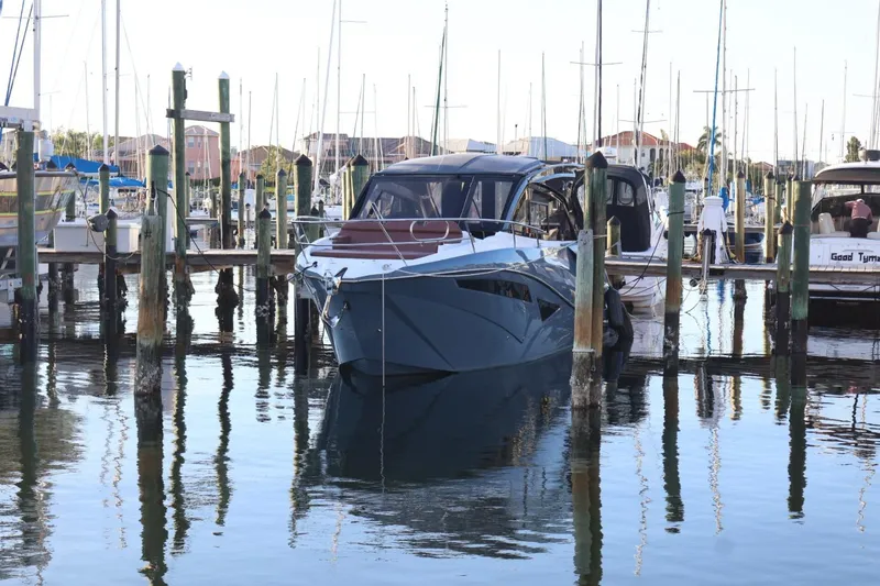 Slide: The Image of 2025 NX Boats 370 docked at a marina, surrounded by sailboats. - 2