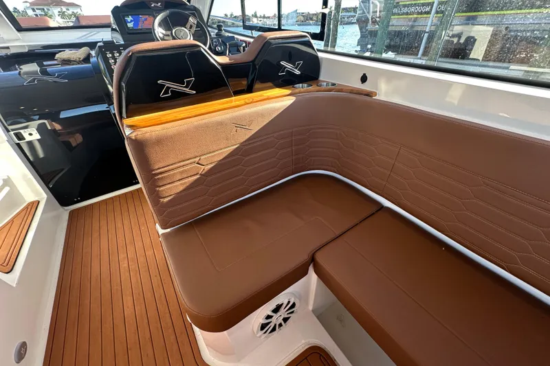 Slide: The Image of Luxurious interior of 2025 NX Boats 370 with brown leather seating and modern dashboard. - 24