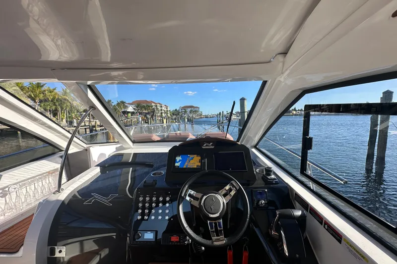 Slide: The Image of Interior view of 2025 NX Boats 370 cockpit with waterfront scenery. - 26
