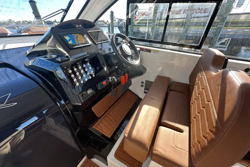 Slide: The Image of 2025 NX Boats 370 cockpit with modern controls and brown leather seating. - 29