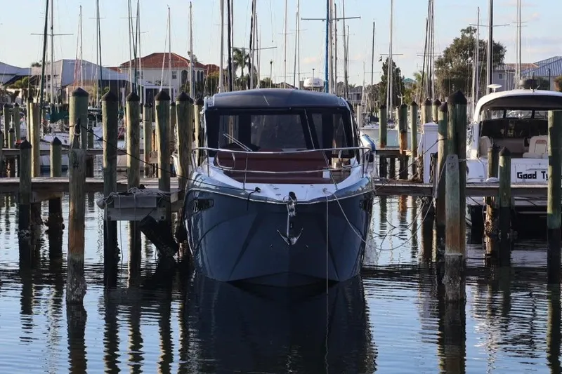 Slide: The Image of 2025 NX Boats 370 docked at a marina, surrounded by sailboats and calm water. - 3