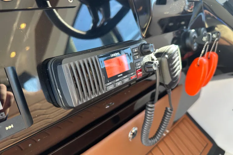 Slide: The Image of Control panel of 2025 NX Boats 370 featuring a Uniden marine radio. - 32