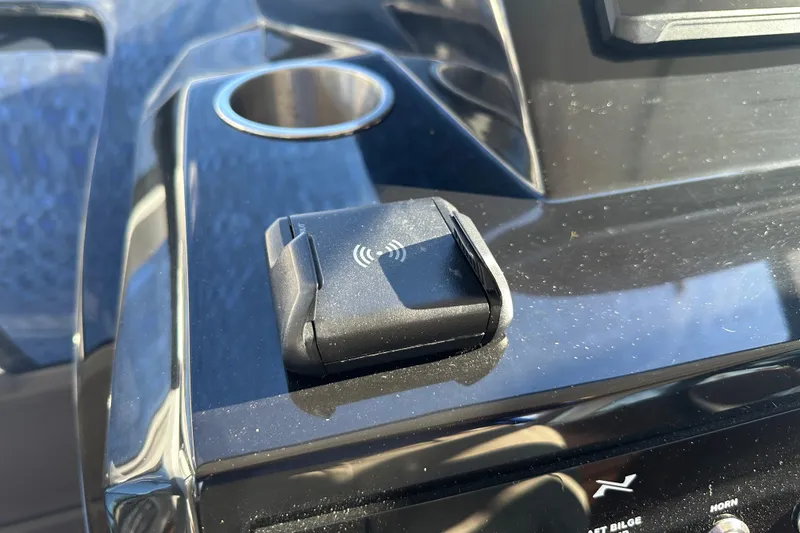 Slide: The Image of Wireless charging pad on 2025 NX Boats 370 dashboard, featuring sleek black design. - 33