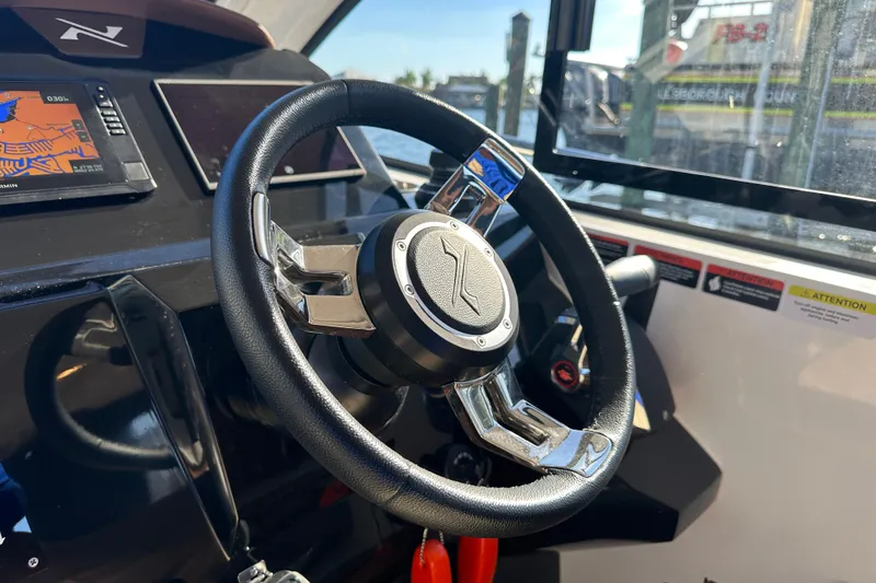 Slide: The Image of Steering wheel of 2025 NX Boats 370 with navigation display and controls. - 39