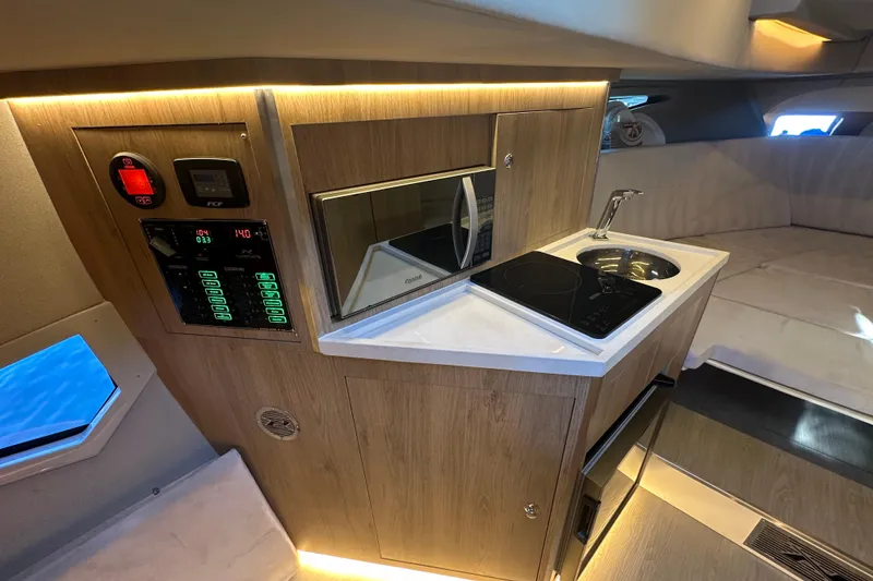 Slide: The Image of Modern kitchen area in 2025 NX Boats 370, featuring sleek appliances and wood finish. - 47