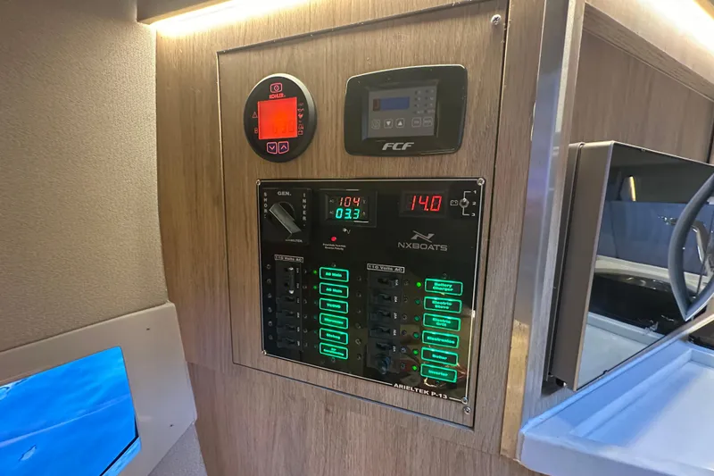 Slide: The Image of Control panel of 2025 NX Boats 370, featuring digital displays and switches. - 48