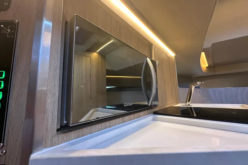 Slide: The Image of Modern kitchen interior of 2025 NX Boats 370 with microwave and sleek design. - 49