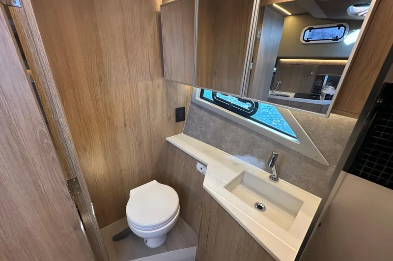 Slide: The Image of Modern bathroom interior on 2025 NX Boats 370, featuring wood paneling and sleek fixtures. - 54