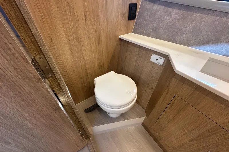 Slide: The Image of Modern bathroom in 2025 NX Boats 370, featuring wood paneling and compact toilet design. - 55