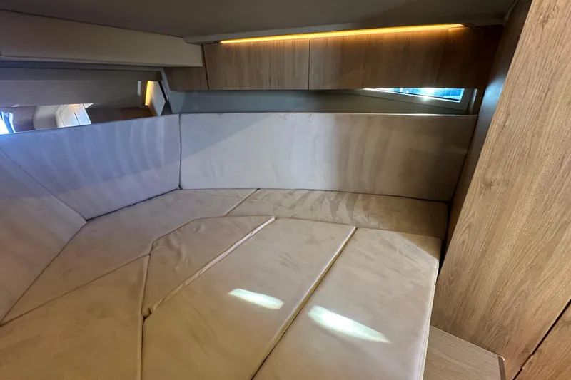 Slide: The Image of Interior cabin of 2025 NX Boats 370, featuring modern wood and beige upholstery. - 64