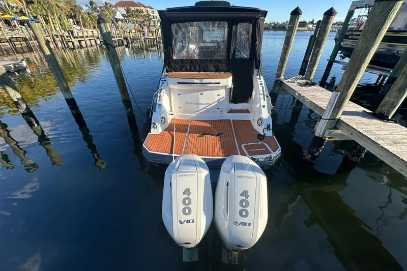 Slide: The Image of 2025 NX Boats 370 with twin Mercury 400 V10 engines docked at marina. - 7