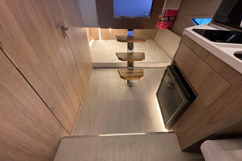 Slide: The Image of Modern interior of 2025 NX Boats 370 with wooden steps and compact kitchen. - 70