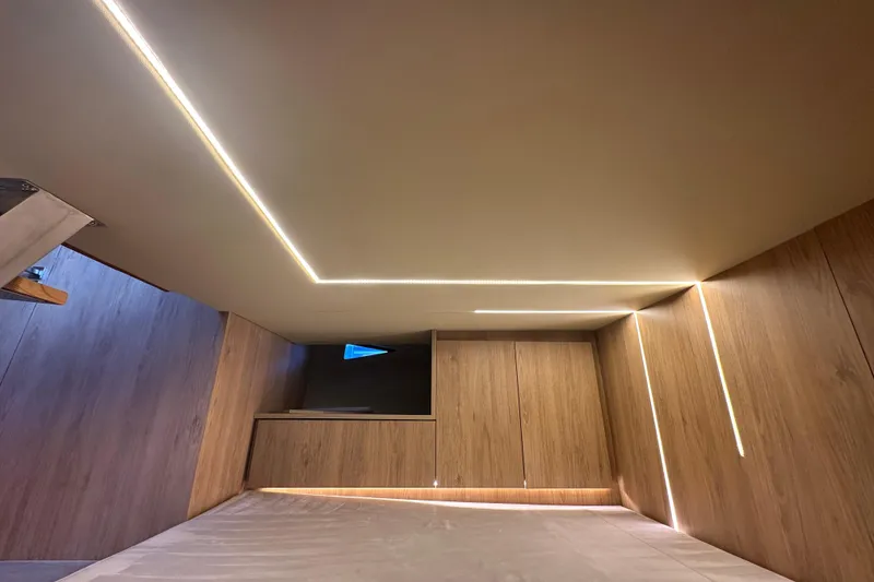 Slide: The Image of Modern interior of 2025 NX Boats 370 with sleek wood paneling and ambient lighting. - 76