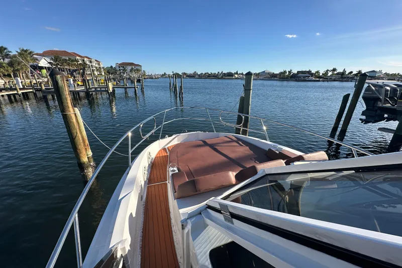 Slide: The Image of 2025 NX Boats 370 docked in a scenic marina under clear blue skies. - 84