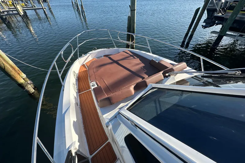 Slide: The Image of 2025 NX Boats 370 with sun deck, docked on calm water. - 85