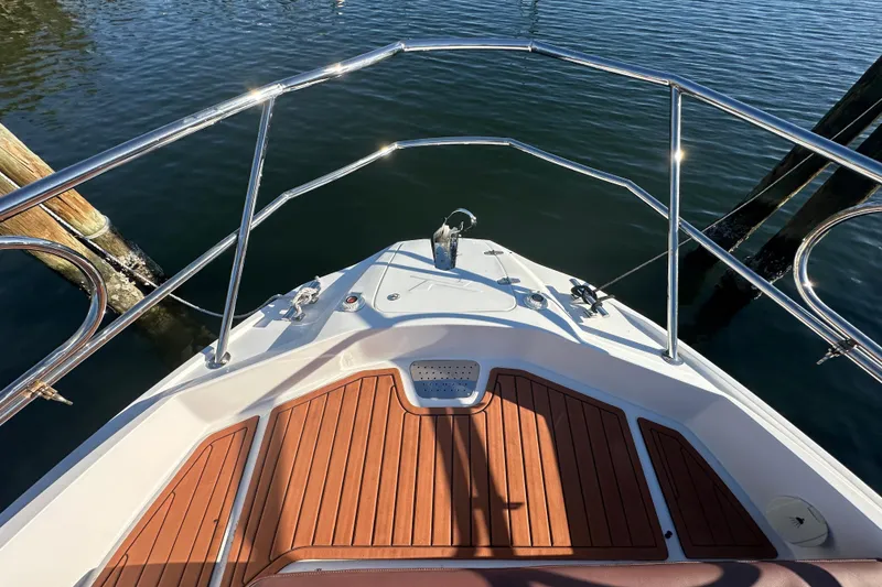 Slide: The Image of Bow view of 2025 NX Boats 370 with teak deck and stainless steel railings. - 87