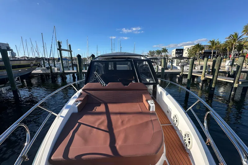 Slide: The Image of 2025 NX Boats 370 at marina, featuring spacious deck and luxurious seating. - 91