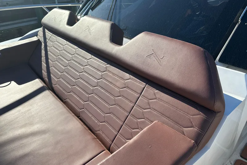 Slide: The Image of Luxurious brown leather seating on 2025 NX Boats 370, featuring hexagonal stitching design. - 94
