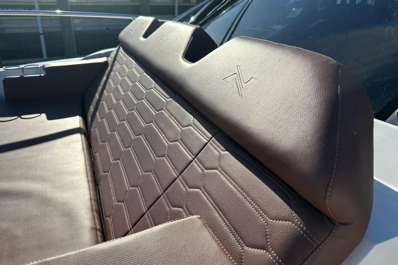 Slide: The Image of Luxurious brown leather seating on 2025 NX Boats 370, featuring hexagonal stitching design. - 95