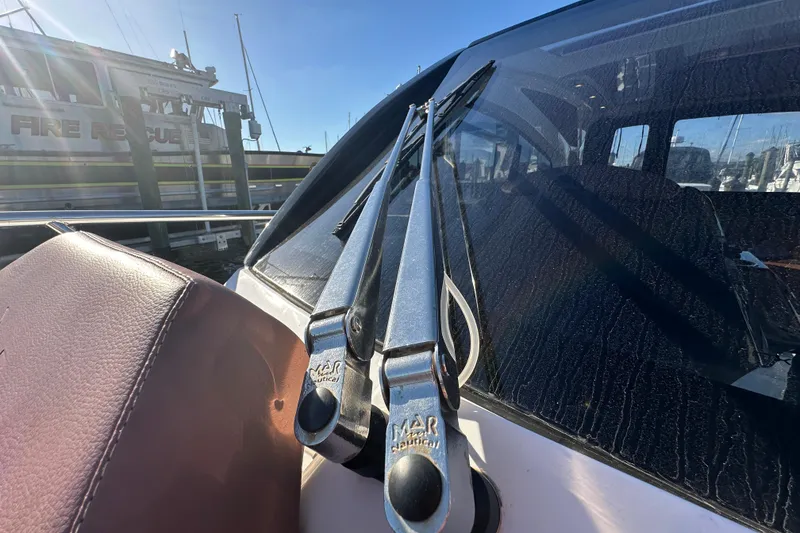 Slide: The Image of 2025 NX Boats 370 windshield wipers and leather seat detail at marina. - 97