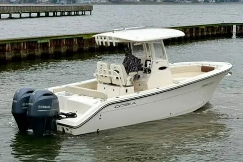 Slide: The Image of 2023 Cobia 262 Center Console boat with dual Yamaha engines on the water. - 1