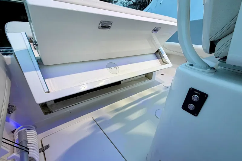 Slide: The Image of 2023 Cobia 262 Center Console boat with open storage compartment and hatch controls. - 10