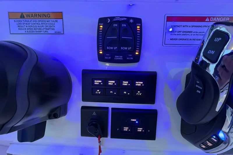 Slide: The Image of Control panel of 2023 Cobia 262 Center Console boat with warning labels and navigation controls. - 13